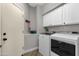 Functional laundry room with modern washer and dryer, and ample cabinet space at 4680 E Nightingale Ln, Gilbert, AZ 85298