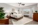 Bright bedroom featuring a wooden bed frame, a decorative rug, and sun-lit windows with shutters at 5113 W Molly Ln, Phoenix, AZ 85083