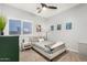 A cozy bedroom featuring a ceiling fan, a large window, and cactus-themed wall art at 5113 W Molly Ln, Phoenix, AZ 85083