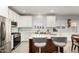 Modern kitchen with white cabinets, stainless steel appliances, island with bar seating, and tile backsplash at 5113 W Molly Ln, Phoenix, AZ 85083