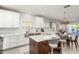 Bright kitchen with white cabinets, stainless steel sink, and a large island with seating at 5113 W Molly Ln, Phoenix, AZ 85083