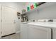 Bright laundry room with white washer and dryer, ample shelving, and storage space at 5113 W Molly Ln, Phoenix, AZ 85083