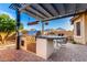 Well-equipped outdoor kitchen features a stainless steel grill and bar, offering a superb outdoor cooking experience at 5113 W Molly Ln, Phoenix, AZ 85083