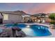 Gorgeous pool area with rock features, lounge chairs, and outdoor kitchen area at 5113 W Molly Ln, Phoenix, AZ 85083