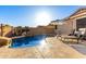 Sunlit pool with rock features, adjacent lounging area, and verdant plantings, offering a serene and inviting outdoor space at 5113 W Molly Ln, Phoenix, AZ 85083