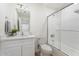 Cozy bathroom with a vanity, mirror, toilet and shower-over-tub with glass enclosure at 5420 W Grove St, Laveen, AZ 85339