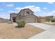 Charming two-story home featuring desert landscaping and a two-car garage on a sunny day at 5420 W Grove St, Laveen, AZ 85339