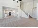Spacious living room that seamlessly connects to the kitchen, featuring a staircase and ample natural light at 5420 W Grove St, Laveen, AZ 85339