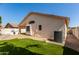 A side view shows an artificial grass backyard and the exterior of the home at 6502 W Wahalla Ln, Glendale, AZ 85308