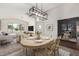 Inviting dining room area featuring modern lighting, neutral tones, and views into the living room at 6502 W Wahalla Ln, Glendale, AZ 85308