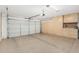 Spacious garage with epoxy flooring, storage cabinets, and an automatic garage door at 6502 W Wahalla Ln, Glendale, AZ 85308
