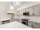 Contemporary kitchen design features an island, stainless steel appliances, and modern lighting fixtures at 6502 W Wahalla Ln, Glendale, AZ 85308