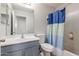 Cozy bathroom featuring modern fixtures and tub/shower combo with light blue curtain and vanity at 7725 S 47Th Ln, Laveen, AZ 85339
