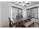 An open dining room with a large wooden table, grey upholstered bench, and wood floors at 7725 S 47Th Ln, Laveen, AZ 85339