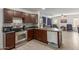This kitchen features dark cabinets, stainless steel appliances, a grey backsplash and grey countertops at 7725 S 47Th Ln, Laveen, AZ 85339