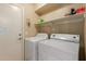 Laundry room equipped with washer, dryer, and storage shelves offers convenience at 7725 S 47Th Ln, Laveen, AZ 85339