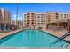 Community pool featuring lounge chairs, blue umbrellas, and building views at 7920 E Camelback Rd # 508, Scottsdale, AZ 85251