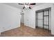 Cozy bedroom with tile flooring, ceiling fan, closet with shelving, and a door to another room at 8202 W Turney Ave, Phoenix, AZ 85033