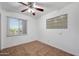 Bright bedroom featuring tile floors, neutral walls, ceiling fan and window with view to backyard at 8202 W Turney Ave, Phoenix, AZ 85033