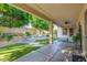 Expansive covered patio overlooking a well-maintained backyard with a fountain and outdoor seating at 9326 E Princess Dr, Mesa, AZ 85207