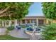 Picturesque backyard with a tranquil fountain, vibrant greenery, and cozy seating area under mature trees at 9326 E Princess Dr, Mesa, AZ 85207