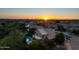 Aerial view of property with pool, lush landscaping, and sunset at 9571 E Nittany Dr, Scottsdale, AZ 85255