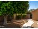 Side yard features lush tree, rock accents, and walkway to gate at 9571 E Nittany Dr, Scottsdale, AZ 85255