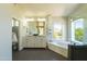 Bright bathroom featuring double vanity, soaking tub with mountain views, and walk-in shower at 9571 E Nittany Dr, Scottsdale, AZ 85255