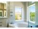 Bright bathroom featuring a soaking tub with mountain views, vanity, and a walk-in shower at 9571 E Nittany Dr, Scottsdale, AZ 85255