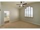 Bright bedroom features neutral tones, a ceiling fan, and plantation shutters at 9571 E Nittany Dr, Scottsdale, AZ 85255