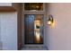 Inviting entryway features a dark wood door, decorative sconce, and 'Welcome' mat at 9571 E Nittany Dr, Scottsdale, AZ 85255