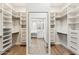 Spacious walk-in closet with ample shelving and a mirror view of the ensuite bathroom at 11008 N 119Th Pl, Scottsdale, AZ 85259