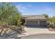 Charming desert home boasts a three-car garage, tile roof, and lush desert landscaping at 11008 N 119Th Pl, Scottsdale, AZ 85259