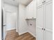 Bright laundry room boasts white cabinets, wood-look floors, and in-unit washer and dryer hookups at 11008 N 119Th Pl, Scottsdale, AZ 85259