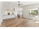 Open-concept living room featuring hardwood floors, high ceilings, and a modern kitchen with stainless steel appliances at 11008 N 119Th Pl, Scottsdale, AZ 85259