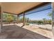 Covered patio features stone flooring and stunning views of the pool and professionally landscaped backyard at 11008 N 119Th Pl, Scottsdale, AZ 85259