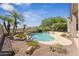Beautiful pool area with palm trees, waterfall feature, mature landscaping, and desert views at 11008 N 119Th Pl, Scottsdale, AZ 85259