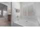 Bright bathroom featuring a soaking tub with window, towel rack, and neutral walls at 11065 W Runion Dr, Peoria, AZ 85373