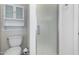 Bathroom featuring toilet, shower with frosted glass door, and small storage unit at 11065 W Runion Dr, Peoria, AZ 85373