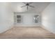 Bright bedroom featuring neutral carpet, ceiling fan, and shuttered windows for natural light at 11065 W Runion Dr, Peoria, AZ 85373