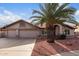 Charming single-story home featuring a three-car garage, palm tree, and desert landscaping at 11065 W Runion Dr, Peoria, AZ 85373
