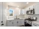 A close-up view of the kitchen featuring new white cabinets and stainless steel appliances at 1118 N 18Th St, Phoenix, AZ 85006