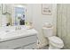 Well-lit bathroom featuring a toilet with a vanity and mirror across the room, with gray flooring at 11951 W Wier Ave, Avondale, AZ 85323