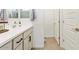 Bathroom featuring a white vanity with modern fixtures, white walls, and multiple paneled doors with bronze hardware at 11951 W Wier Ave, Avondale, AZ 85323