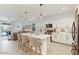 Bright kitchen boasts a large island with seating, white cabinets and stainless steel appliances at 11951 W Wier Ave, Avondale, AZ 85323