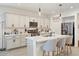 Bright kitchen boasts a large island with seating, white cabinets and stainless steel appliances at 11951 W Wier Ave, Avondale, AZ 85323