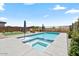 Beautiful pool with integrated spa, artificial turf, lounge seating, and flowering bushes providing privacy at 11951 W Wier Ave, Avondale, AZ 85323