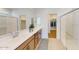 Bright bathroom featuring double vanity, large mirror, and walk-in closet access for ample storage at 12550 W Luxton Ln, Avondale, AZ 85323