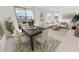 Open-concept dining area with modern furniture and ample natural light, adjacent to the living room at 12550 W Luxton Ln, Avondale, AZ 85323