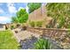 Landscaped backyard featuring well-manicured greenery, stacked stone planters, and desert plants at 12932 W Cassia Trl, Peoria, AZ 85383